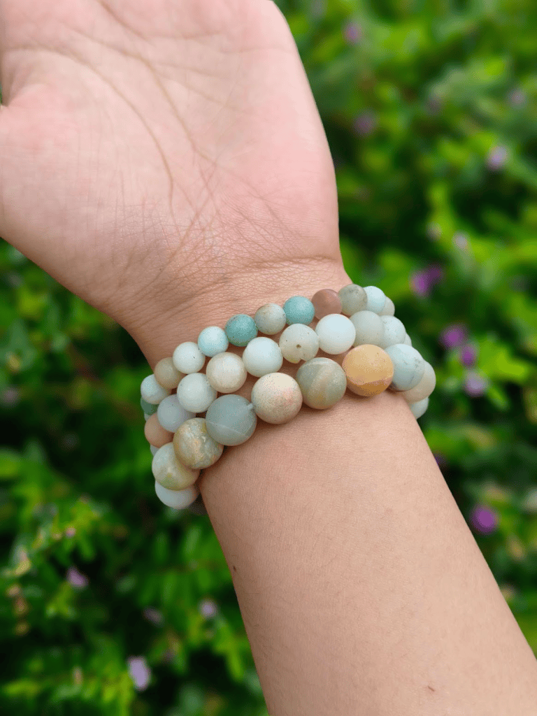 Amazonite round-bead bracelets worn together on a wrist outdoors.