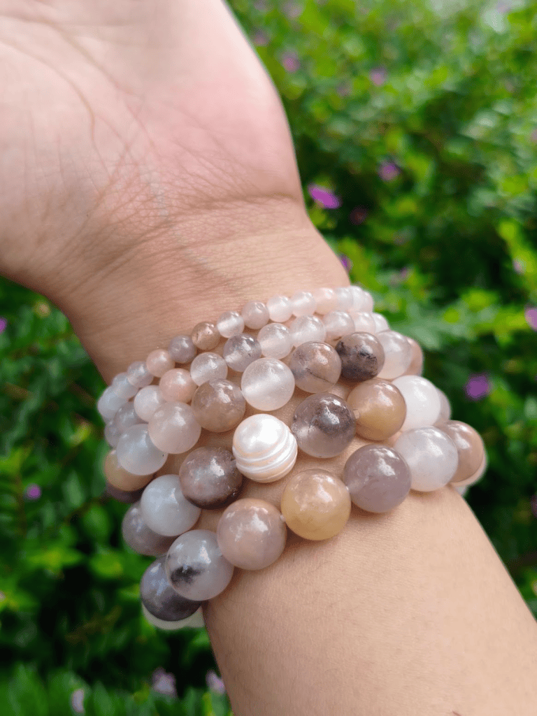 Chalcedony round-bead bracelets worn together on a wrist outdoors.