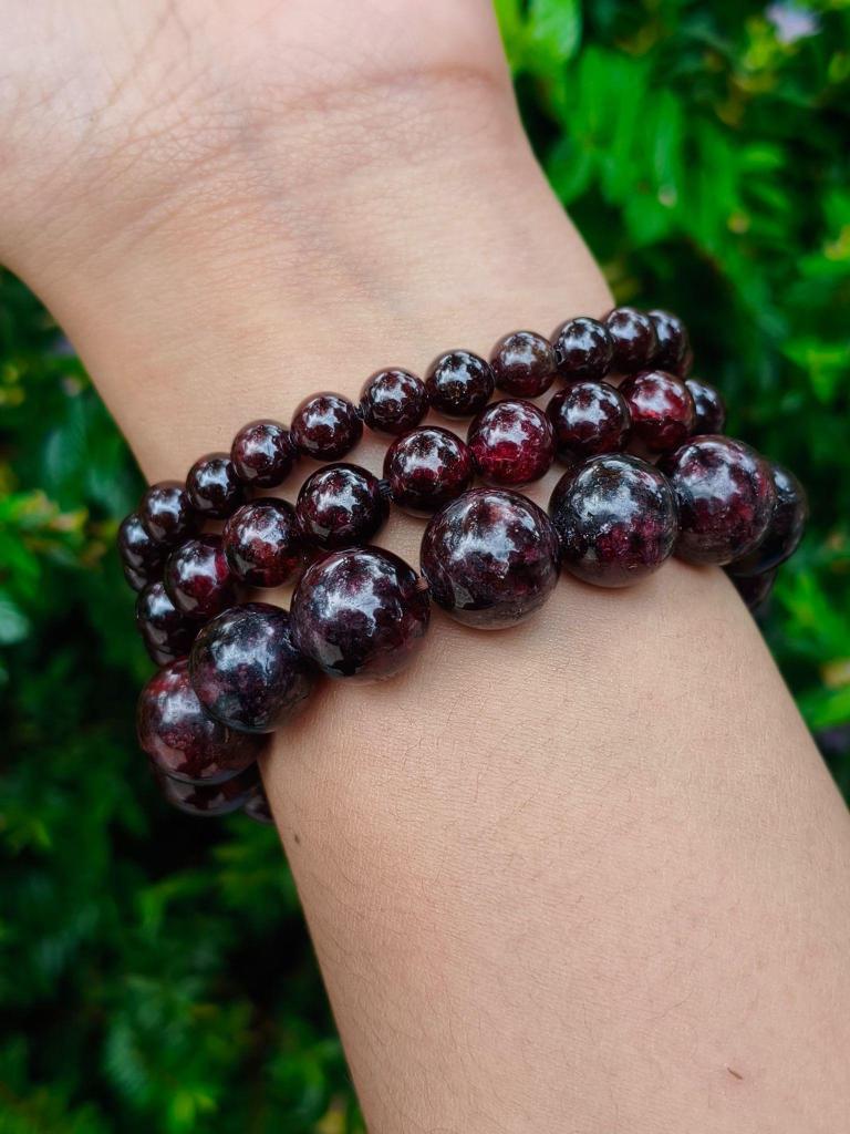 TÁWID Garnet round-bead bracelet worn on a wrist.