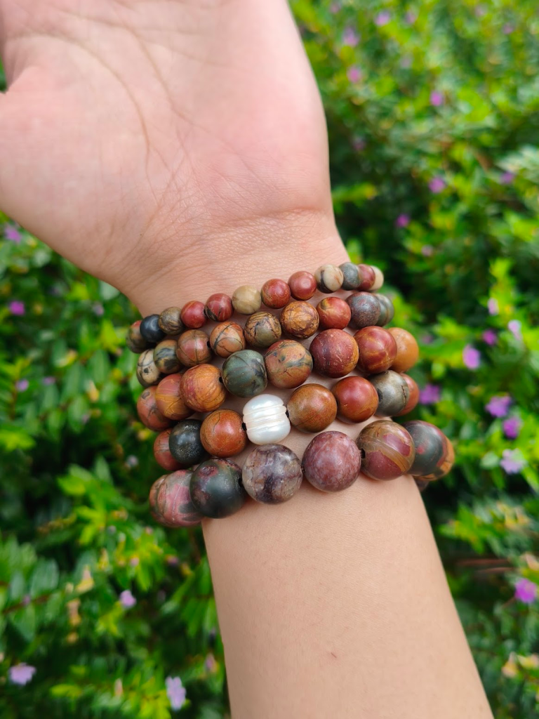 Picasso Jasper round-bead bracelets worn together on a wrist outdoors.