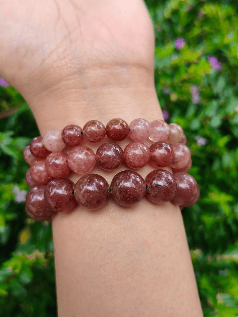 TÁWID Strawberry Quartz round-bead bracelet worn on a wrist.