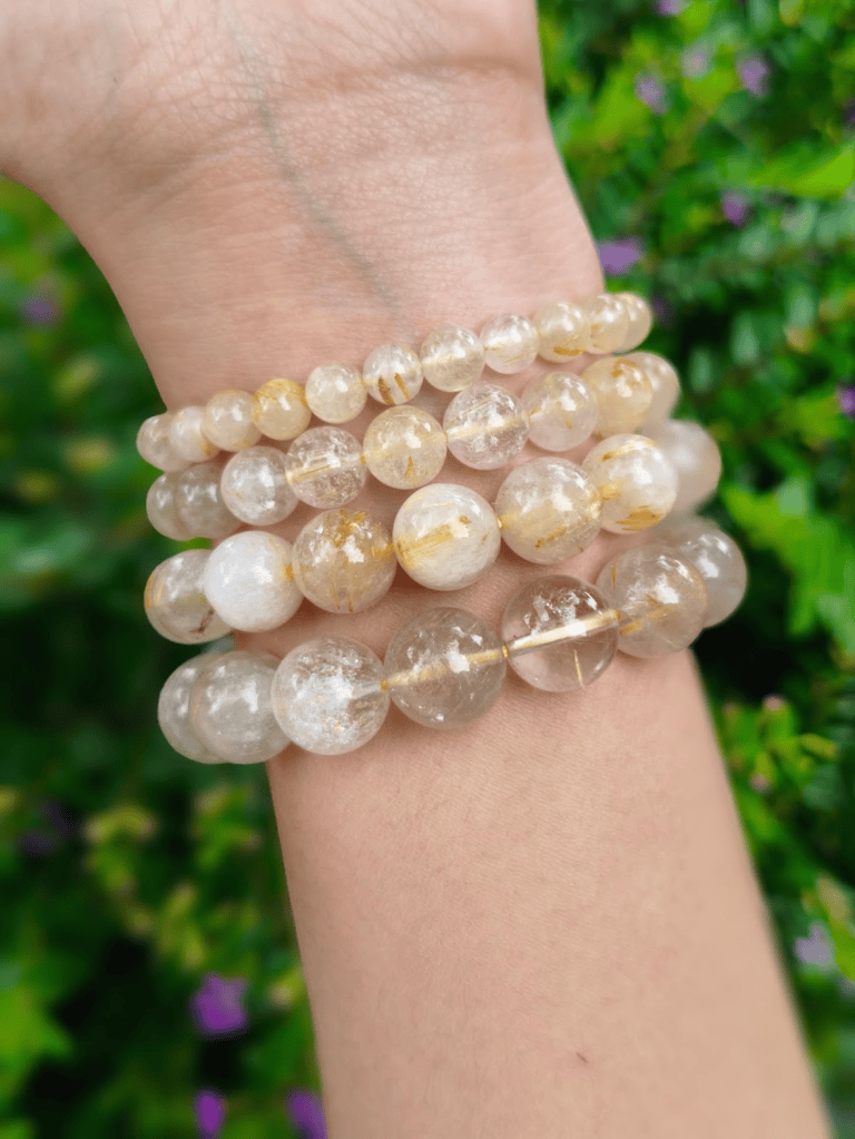 TÁWID Rutilated Quartz round-bead bracelet worn on a wrist.